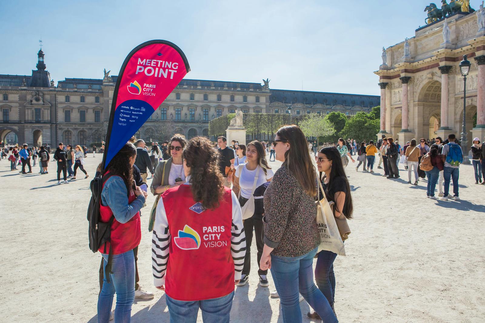 Visiteurs et bénévoles devant le Musée du Louvre