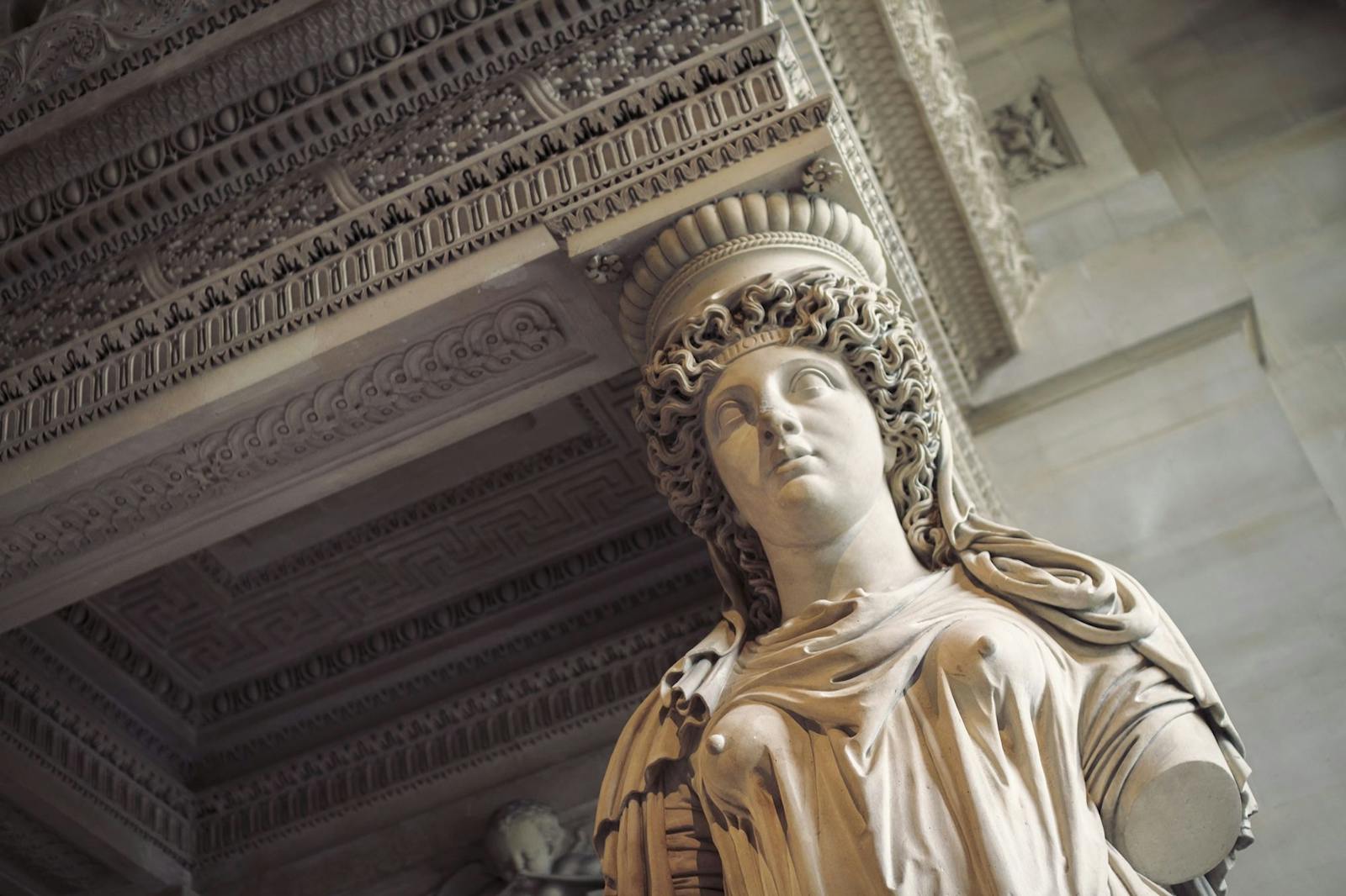 Statue féminine sous l'entablement au Musée du Louvre