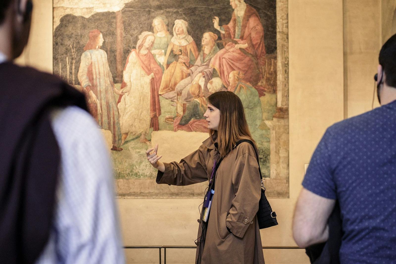 Guia turístico diante de afresco no Museu do Louvre